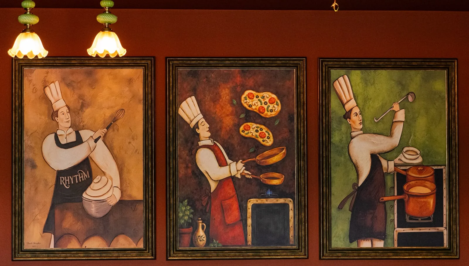 Three colourful framed illustrations of chefs on the restaurant’s terracotta wall