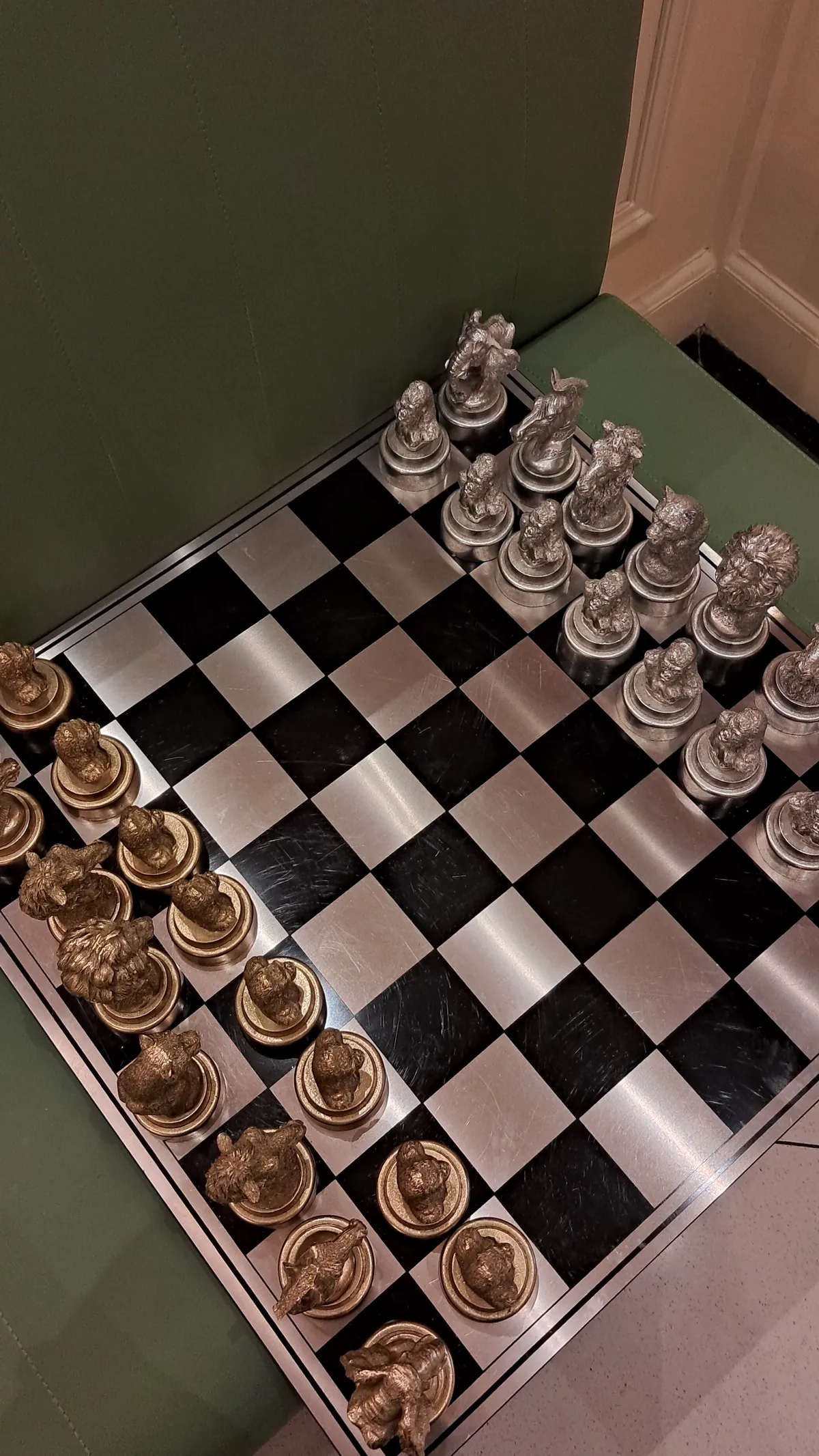 A chessboard with silver-coloured pieces beside the sage seating at RHYTHM