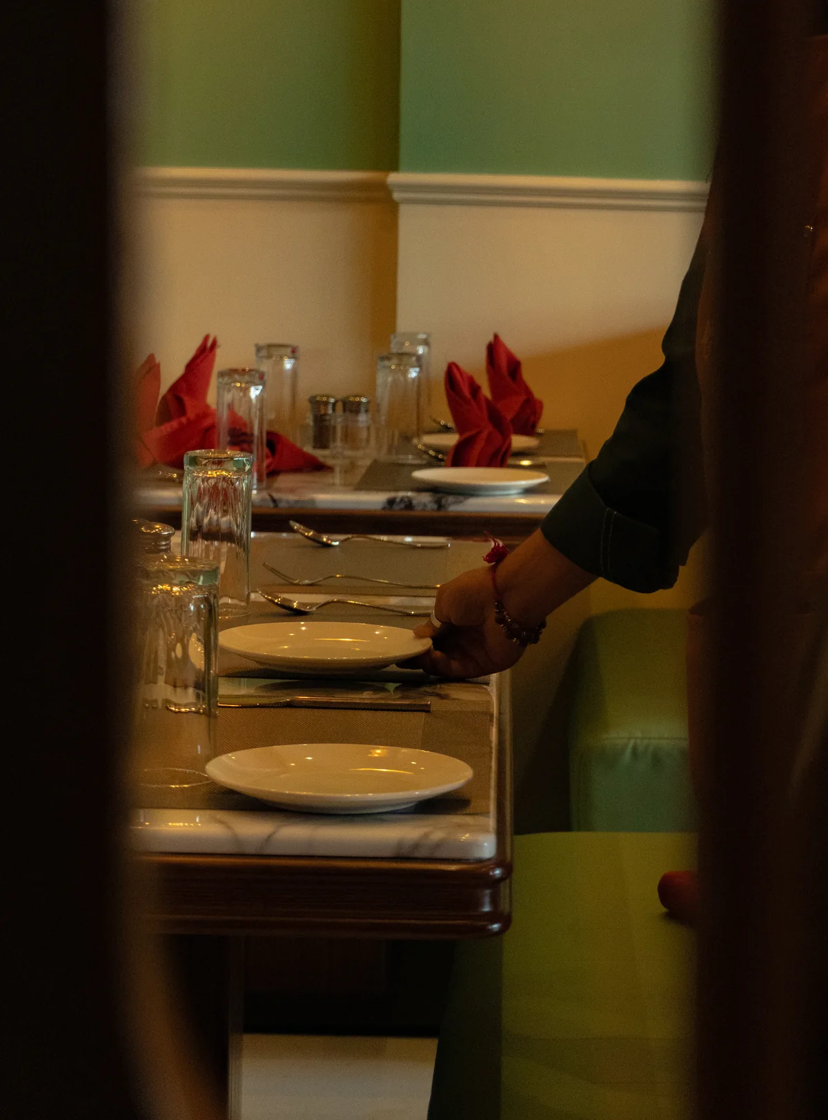 A member of the RHYTHM team placing a plate on a table beside the sage booths